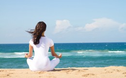 young beautiful woman meditation on beach